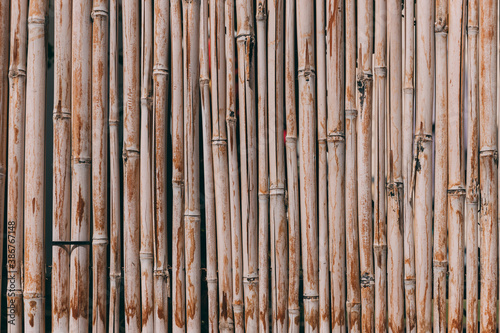 Bamboo fence background. Natural bamboo pattern. Wall texture background for interior or exterior design. Wooden texture background. Orange old grungy handicraft of bamboo weave pattern fence