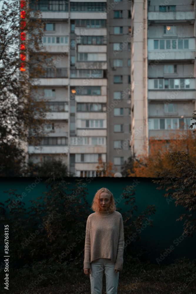 Young girl on the background of a residential building