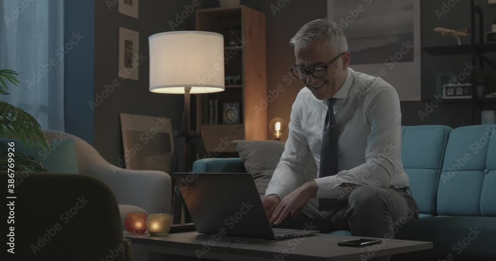 Happy businessman videocalling at night