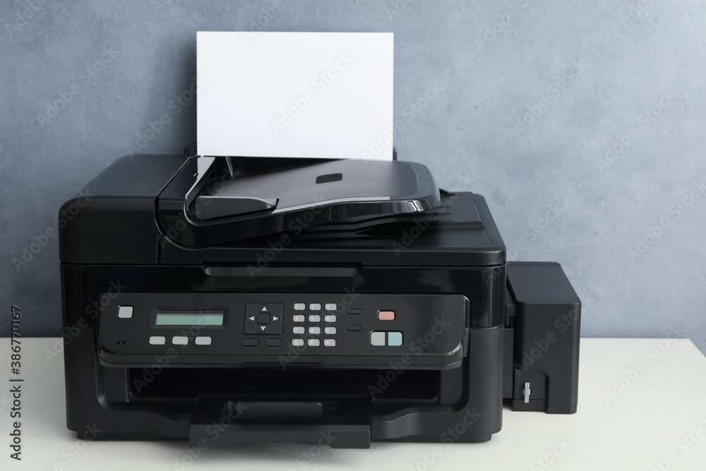 Modern printer with paper on white table Modern printer with paper on white table