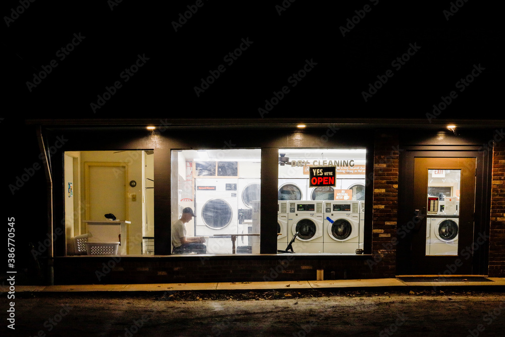 Canaan, Connecticut USA A single man sits inside of a laundromat at