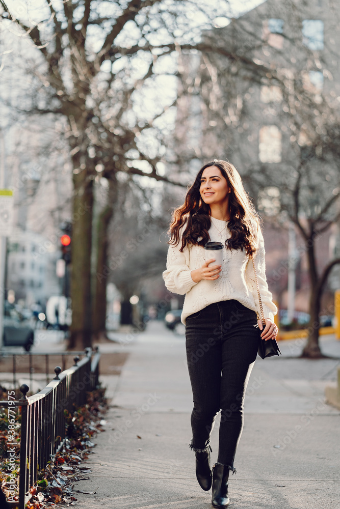 Elegant girl walk in a winter city. Woman in a white knited sweater. Beautiful lady with dark hair. Elegant girl walk in a winter city. Woman in a white knited sweater. Beautiful lady with dark hair.