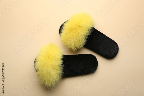 Pair of soft slippers on beige background, flat lay