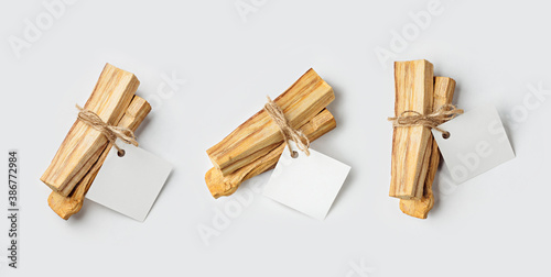 Palo Santo wood sticks tied in bunches with tags on a light background. Top view. Organic holy tree incense from Latin America. Color photo close-up of natural frankincense.