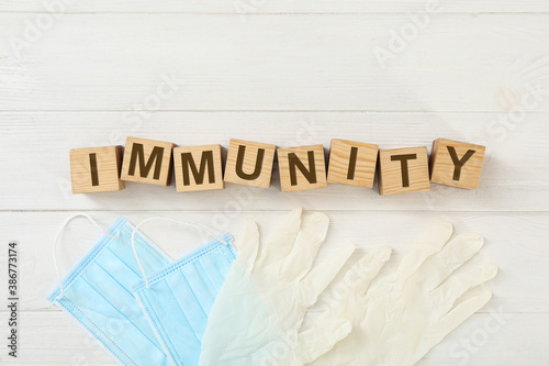 Cubes with word Immunity and medical items on white wooden table, flat lay photo