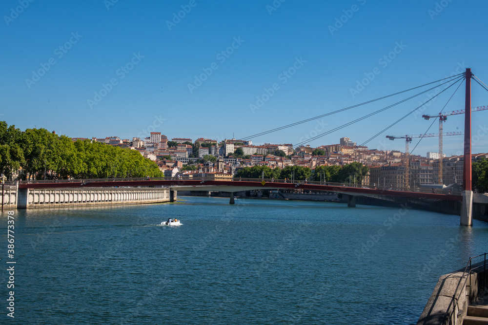 Vue du Rhône et d'un pont de la ville de Lyon avec les rives et les quartiers urbanisés un jour ensoleillé avec un ciel bleu sans nuage
