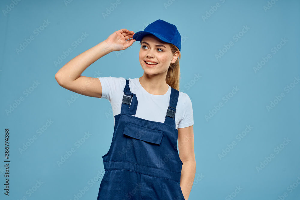 Woman in work uniform blue cap carriage delivery service courier blue background Woman in work uniform blue cap carriage delivery service courier blue background