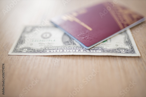 Two Dollars Bill Partially Inside a Sweden Passport on a Wooden Table