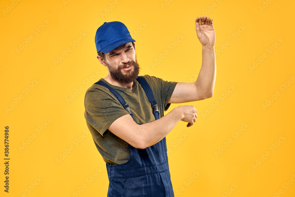 man in work uniform rendering service forklift work lifestyle yellow background