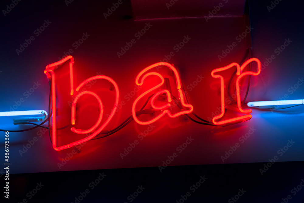 Red neon bar sign with blue neon lines on the sides, lower case letter lights. Concept of night life in city and place to relax after a hard week of work in the city. Red neon bar sign with blue neon lines on the sides, lower case letter lights. Concept of night life in city and place to relax after a hard week of work in the city.