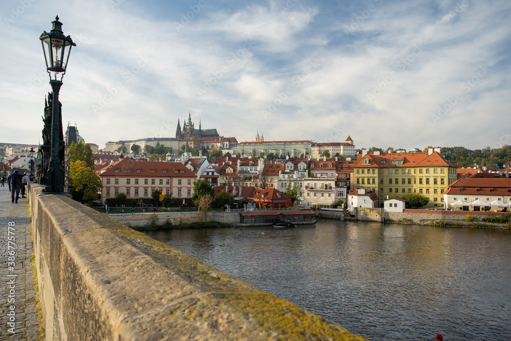 Obraz premium Vltava river and Prague Castle St. Vitus Cathedral and Charles Bridge in the center of Prague at sunset. there are reflections on the river surface and the sky is illuminated by the sun