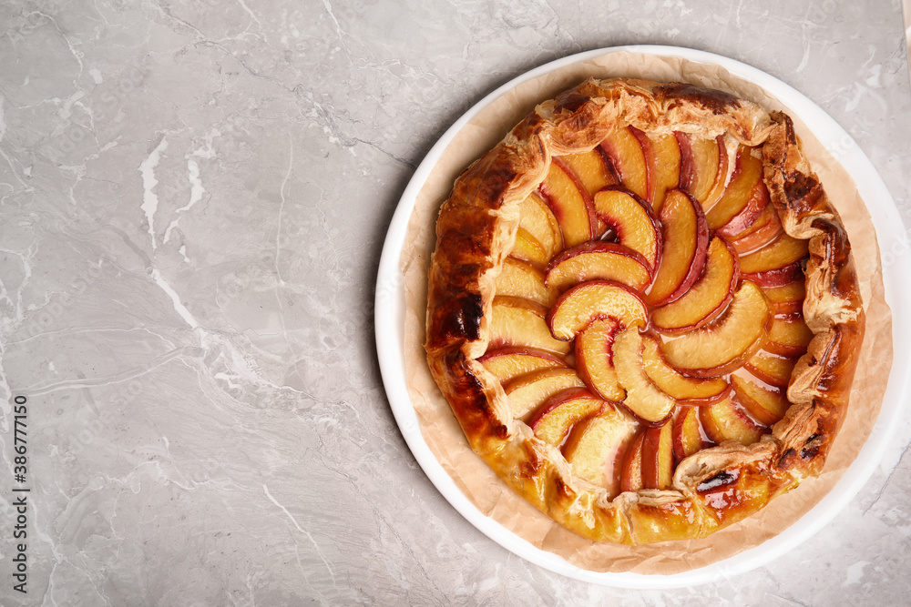 Delicious fresh peach pie on grey table, top view. Space for text Delicious fresh peach pie on grey table, top view. Space for text