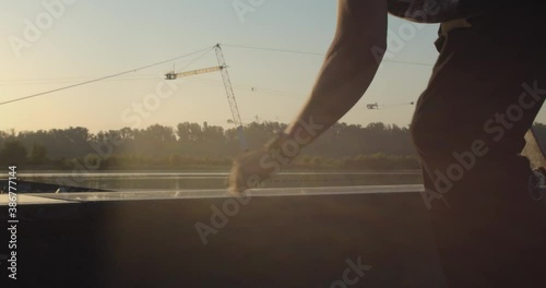 Skateboarder is waxing a curb before the rail slide trick, street sports, 4k photo