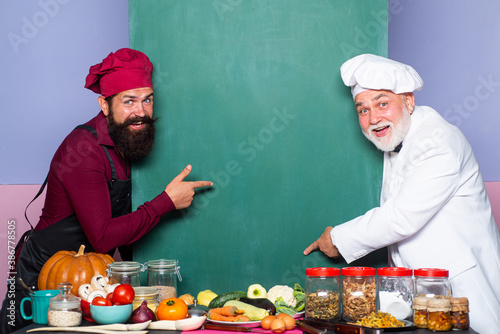 Funny Chefs men. Empty menu chalkboard or blackboard with copy space for text menu. Male chef  cook or baker with blank board. Man cook pointing finger.