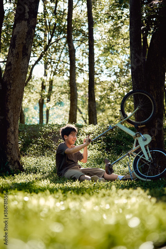 Obraz na płótnie A boy still smiling even he has ridden the bicycle crashed on the tree