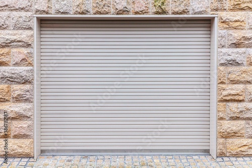 Automatic white roller shutter doors on the ground floor of the house