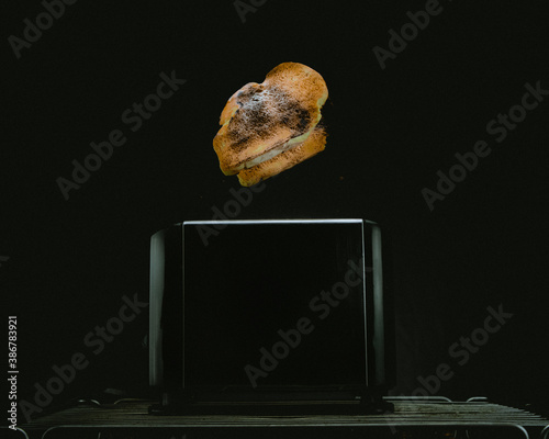 Pan saliendo del tostador con fondo negro minimalista