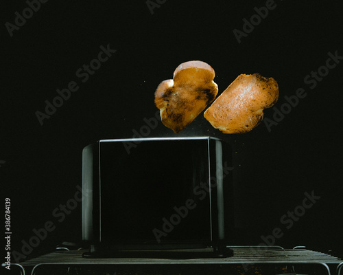 Pan saliendo del tostador con fondo negro minimalista