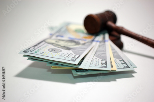 Obraz na plátně Hammer of a judge on a heap of dolor coins, a legal right