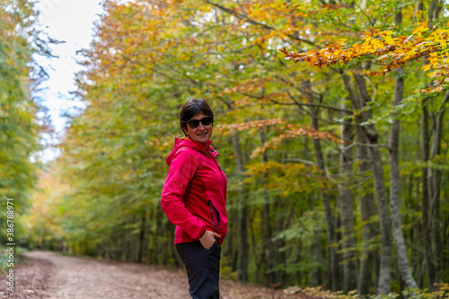 young woman walking among beech trees in autumn © JuanFrancisco