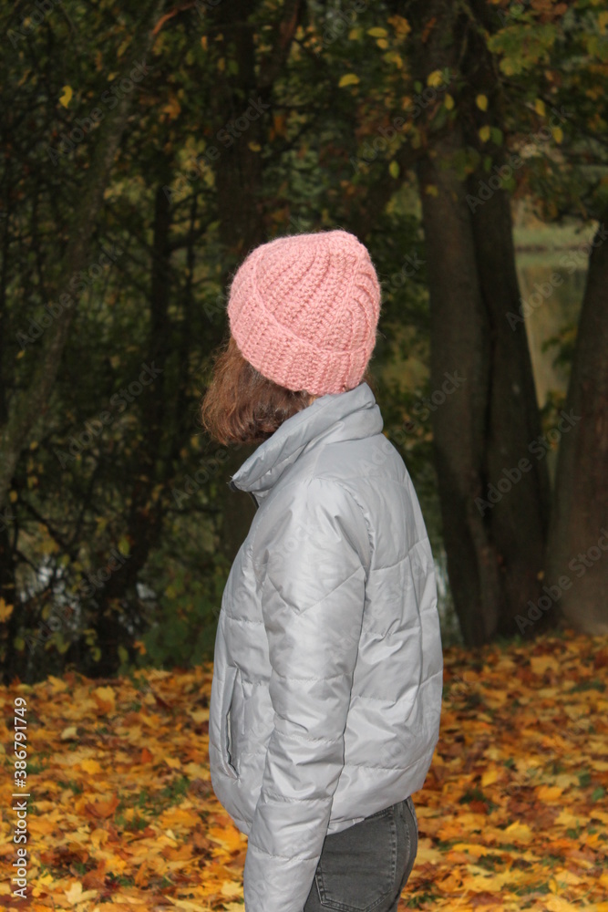 Girl in a warm 2-colored hat, autumn forest Girl in a warm 2-colored hat, autumn forest