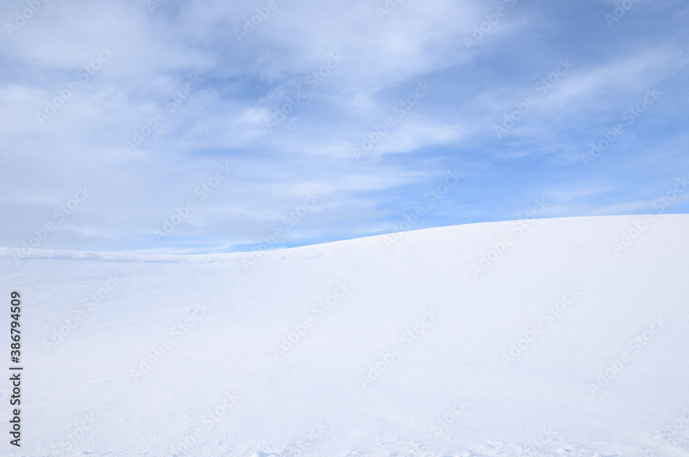 Cold Cirrus Clouds in an otherwise Blue Sky over a Snow Covered Countryside in the Palouse of Eastern Washington State, USA
