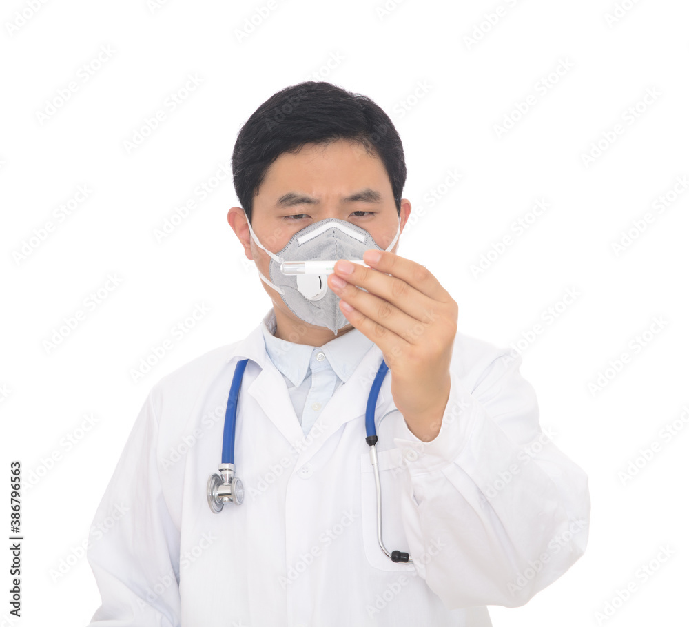 A male doctor wearing a mask in the hospital checks a thermometer