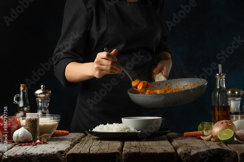 Εκτύπωση καμβά Professional chef pours by ladle chicken curry from pan wok to white bowl