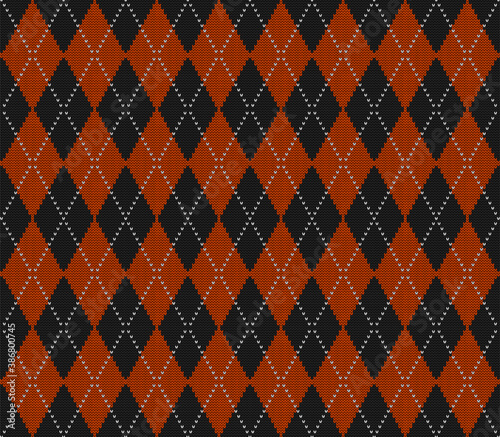 Knitted argyle Halloween pattern. Wool knitinng. Scottish plaid in orange and black rhombuses. Traditional  Scottish background of diamonds . Seamless fabric texture. Vector illustration