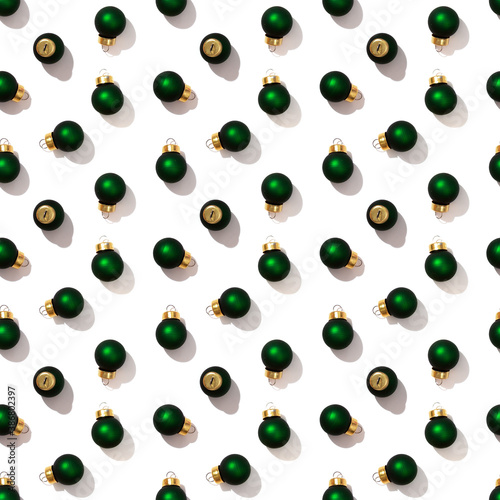 Seamless regular creative pattern with bright shiny little green Christmas balls isolated on white background. Printing on fabric, wrapping paper.