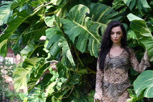 Beautiful young woman, portrait, palm trees in background.