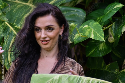 Woman model with natural makeup front of green leaf