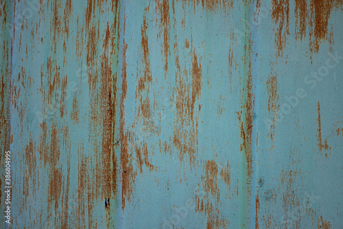 Rusty metal surface texture with peeling and cracked blue paint. Background