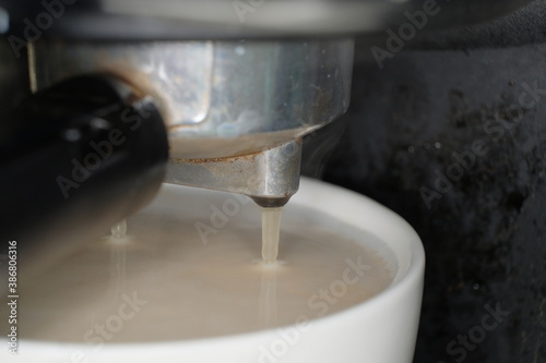 coffee preparation. Coffee is pouring in cup macro shot