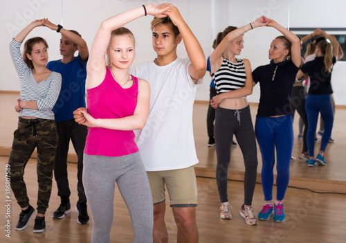 Group of english positive teen dancing salsa in dance studio