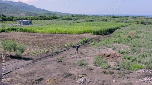Man tills soil with spade. Aerial circling view