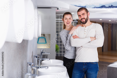 Young family couple choosing bathroom sink in bathroom fixtures store