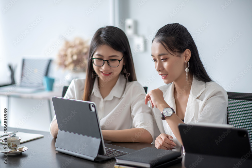 Two beautiful young asian woman working in office on laptop computer. Two beautiful young asian woman working in office on laptop computer.