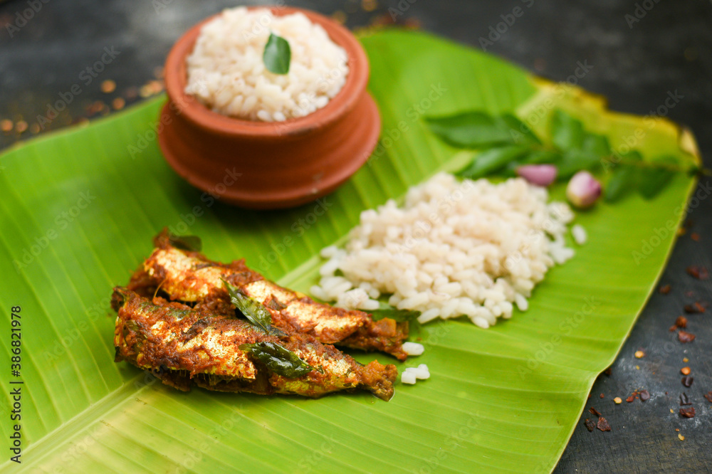 Top view Sardine fish curry spicy Kerala fish curry rice on banana leaf