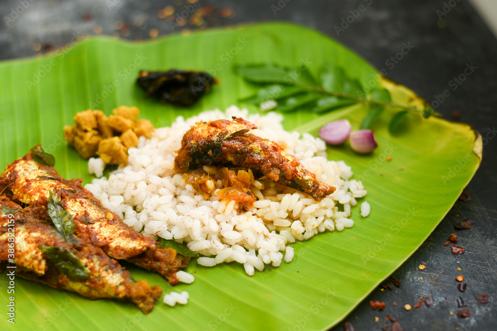 Top view Sardine fish curry spicy Kerala fish curry rice on banana leaf