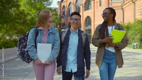 Happy multiracial students outdoor walking and talking to each other