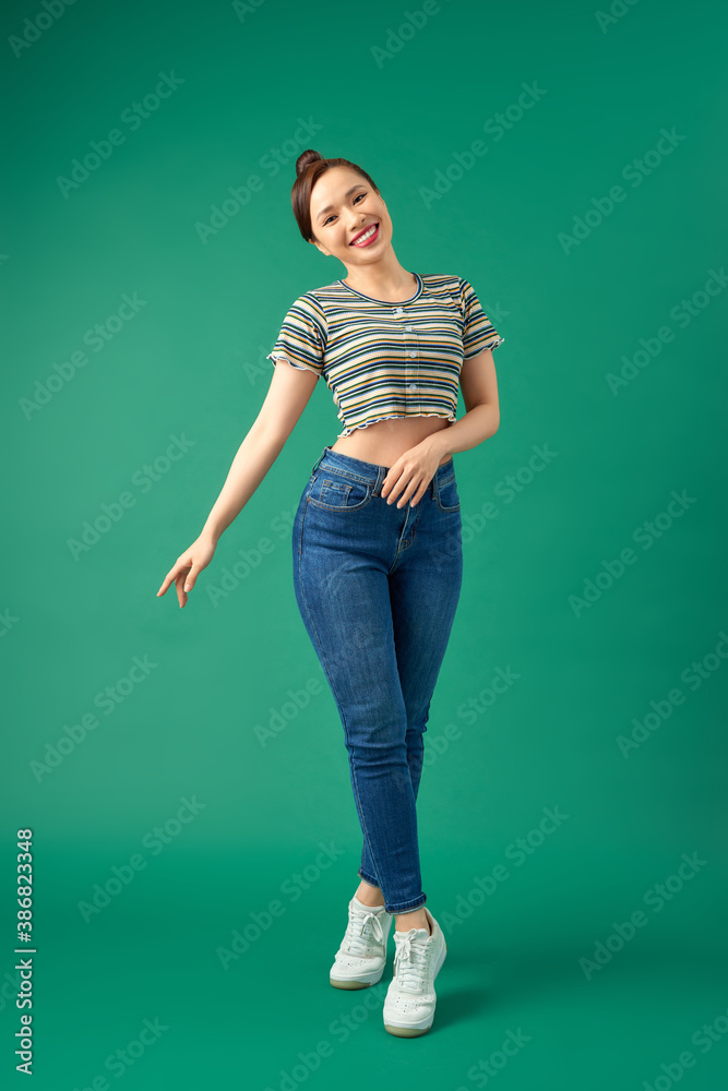 Full length image of beautiful Asian woman having fun and dancing isolated over green background Full length image of beautiful Asian woman having fun and dancing isolated over green background