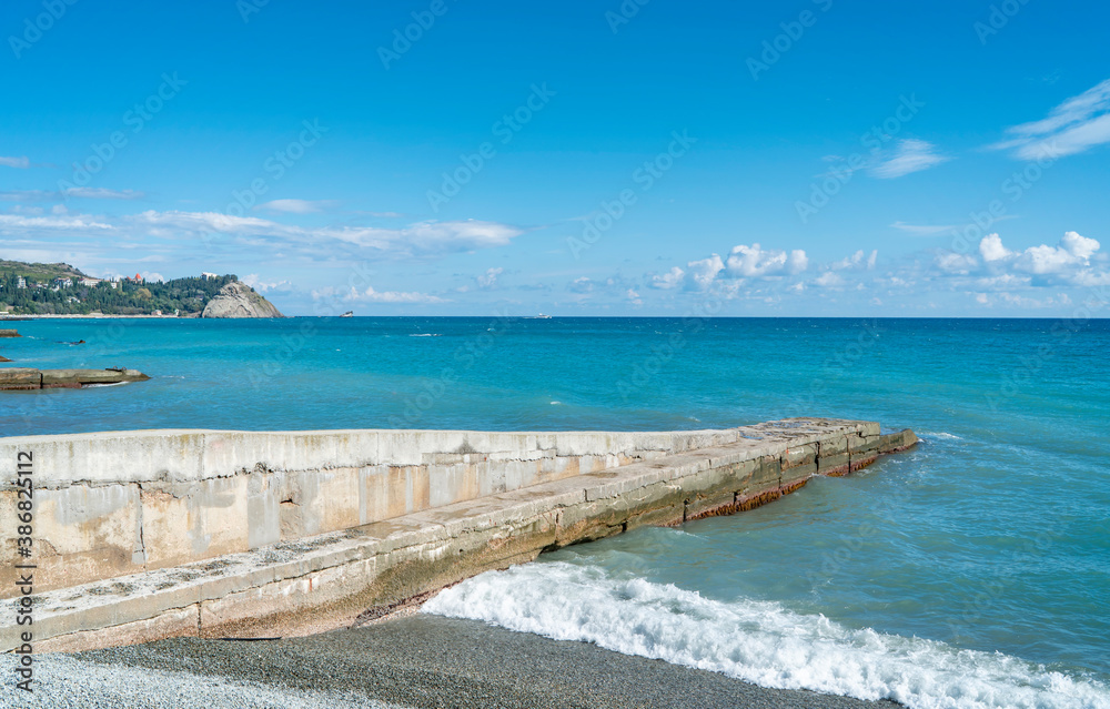 PARTENIT, CRIMEA - a landscape view of the sea with a breakwater, clouds. PARTENIT, CRIMEA - a landscape view of the sea with a breakwater, clouds.