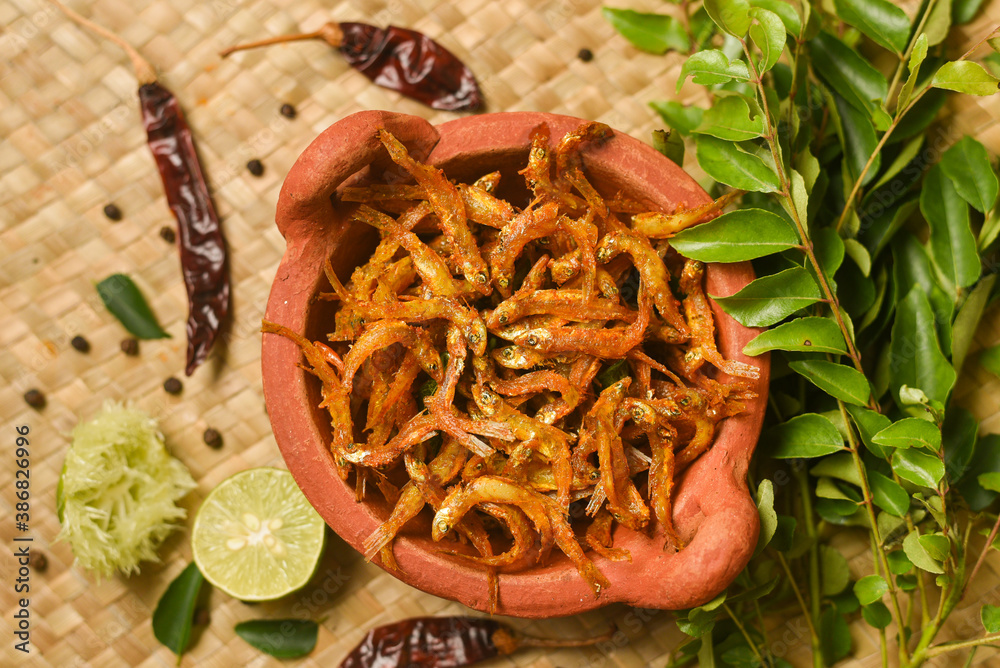 Fotka „Top view of spicy hot anchovy fry Kerala fish curry. Indian food