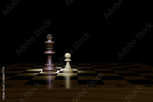 chess pieces are on black background with copy space. king and pawn