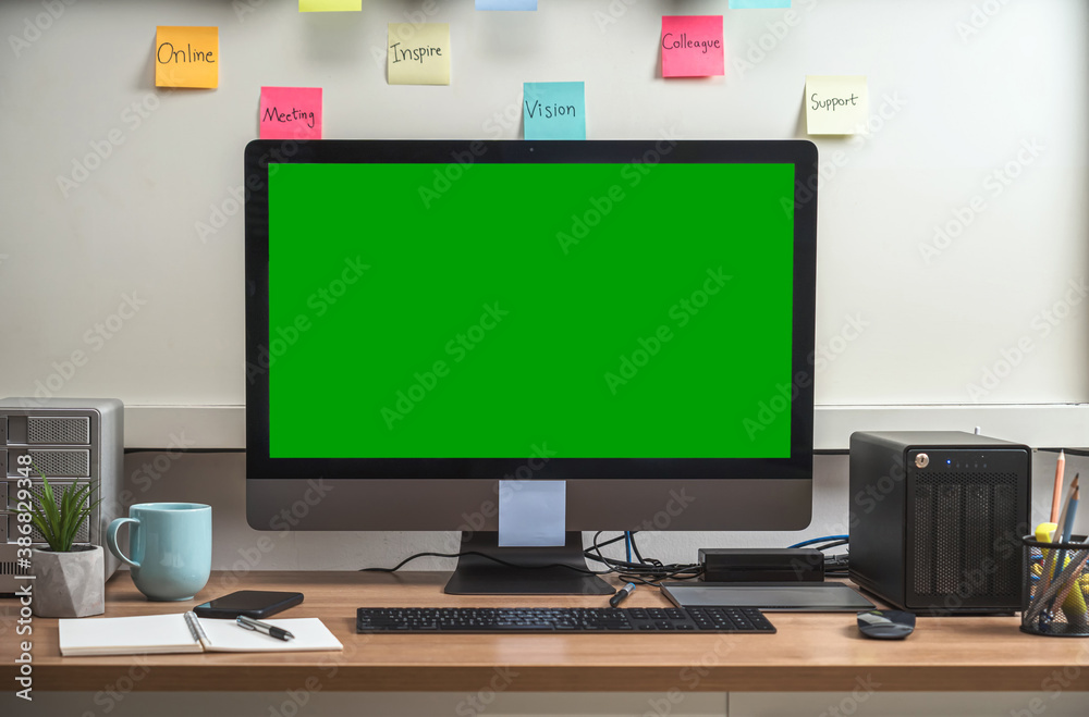 Computer desktop with Stationery and device showing the green screen via video conference when Coronavirus outbreak, Covid-19 pandemic,home office and new normal Concept Computer desktop with Stationery and device showing the green screen via video conference when Coronavirus outbreak, Covid-19 pandemic,home office and new normal Concept