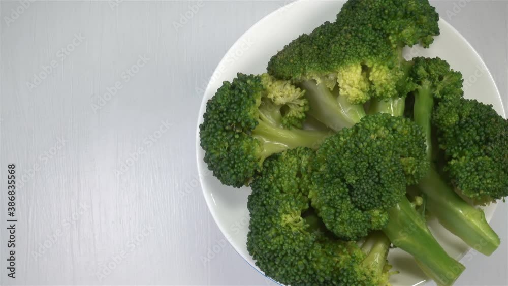 4K view of rotating broccoli cabbage slices on white plate 4K view of rotating broccoli cabbage slices on white plate