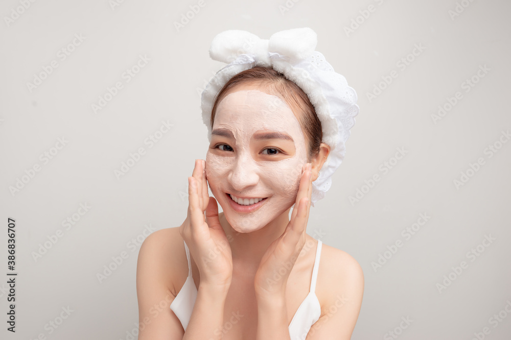 a cute young girl enjoying spa treatments, put a clay mask on her face, smiling a cute young girl enjoying spa treatments, put a clay mask on her face, smiling