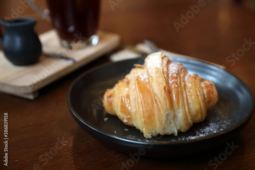 croissant with coffee close up on wood background