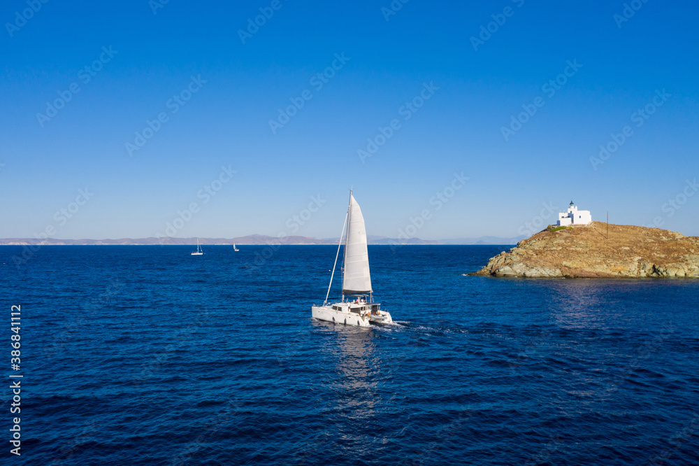 Fototapeta premium Sailing boat catamaran with white sails, rippled sea background